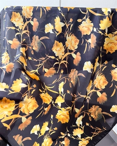 Macro detail of elegant floral print on translucent satin silk fabric with yellow flowers
