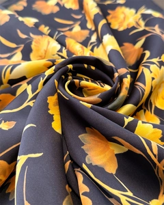 Detailed view of floral printed satin scarf fabric with artistic swirl fold and glossy finish