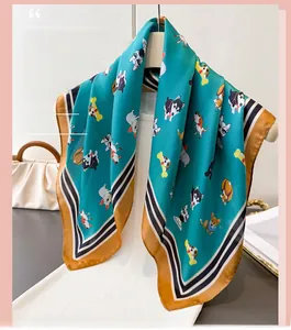 Détail du foulard en soie turquoise avec imprimés chiots et bordure rayée élégante