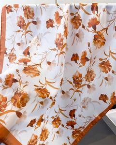 Close-up of premium satin silk scarf with orange floral prints and rolled edges