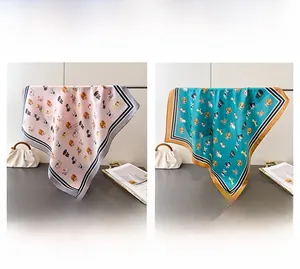 Détail d'un foulard en soie à imprimé chiot en rose gris et vert avec bord rayé