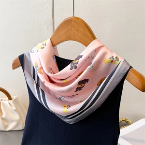 Foulard soyeux rose avec imprimés chiots et bordure rayée sur cintre en bois