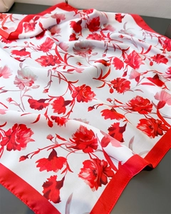 Detail view of satin silk scarf featuring elegant red floral prints and silk texture