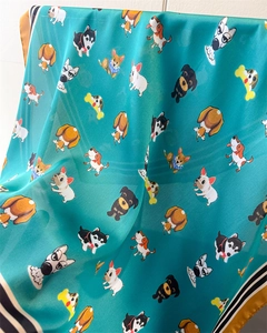 Détail du tissu soyeux de l'écharpe avec motifs de chiots et texture lisse de haute qualité