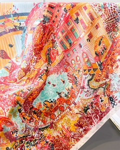 Close-up of silk scarf showing detailed artistic prints of carriages and horse patterns