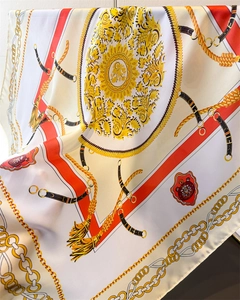 Détail d'un foulard en soie de luxe avec imprimé baroque, chaînes dorées et glands