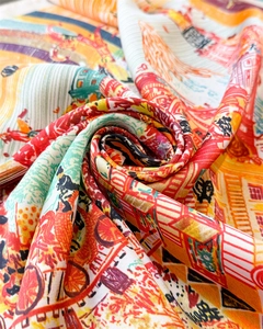 Macro shot of elegant printed silk scarf showing artistic Paris patterns and vibrant colors