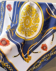 Détail d'un foulard en satin aux motifs de chaînes dorées et blasons royaux chic