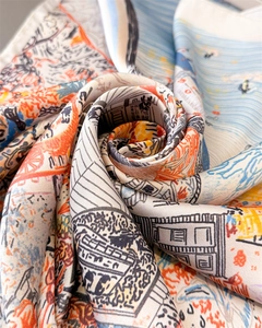 Detailed macro view of the smooth silk texture and artistic landscape print on scarf