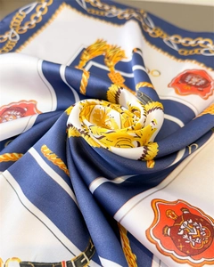 Détail d'un foulard en soie de luxe avec motifs de chaînes dorées et imprimés nautiques