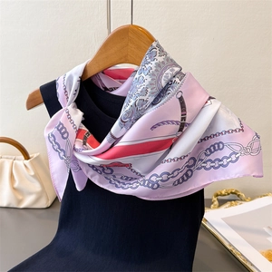 Gros plan d'un foulard élégant en soie à motif cachemire noué sur un débardeur noir