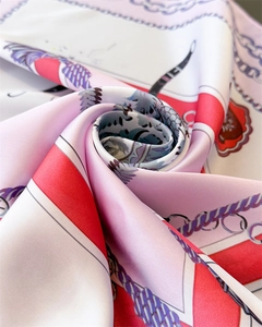 Gros plan d'un foulard carré en satin de luxe avec motifs de chaînes et texture de soie rose