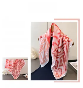 Detail showing the elegant orange silk-like scarf with animal and stripe patterns