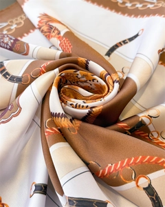 Détail du foulard en soie de luxe montrant des motifs de chaînes et ceintures