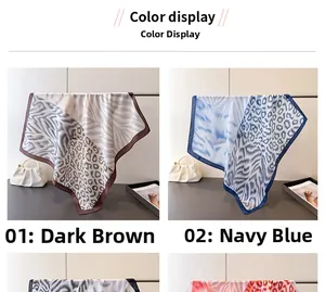 Detailed view of animal print satin scarves in dark brown and navy on display stands