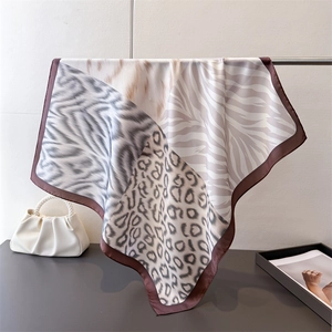 Detail of silk square scarf featuring leopard and zebra print patterns with satin finish