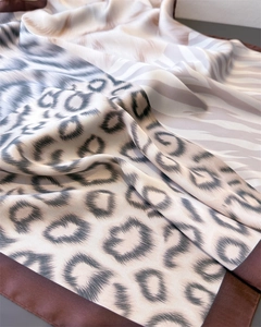 Detailed view of silk scarf fabric showing elegant leopard and zebra print patterns