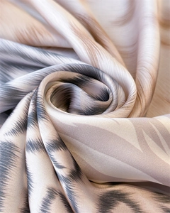 Detail shot of silk scarf showing abstract gray and beige tie-dye texture with silky luster