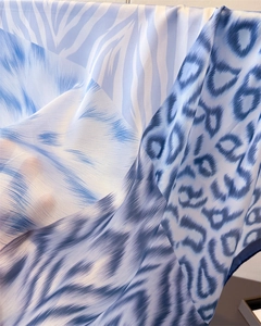 Macro view of semi-transparent blue silk scarf with leopard and zebra animal patterns