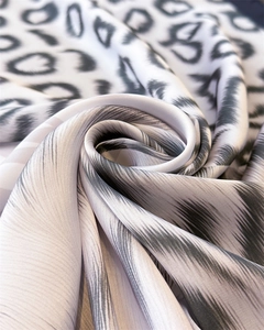 Macro detail of leopard print scarf showing soft silk texture and spiral draped fabric