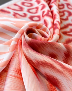 Detailed macro view of silky orange animal print fabric with smooth satin texture