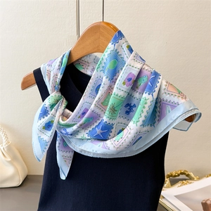 Detail of printed silk scarf with stamp patterns of lobster and lemon on black vest