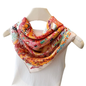 Elegant silk-like square scarf with colorful abstract print draped on a white vest
