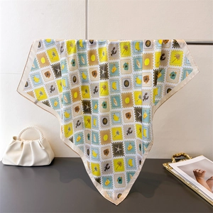 Detail of printed silk scarf with tropical fruit and marine life patterns on metal rack