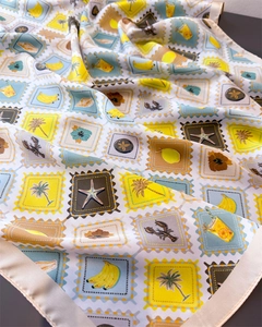Detail of satin scarf featuring tropical stamps with bananas, lobsters, and floral prints
