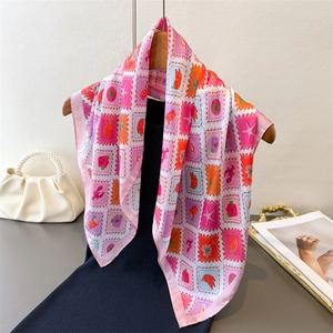 Elegant stamp print silk scarf with floral and sea elements over a black dress