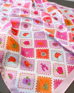 Close-up of silk scarf with stamp prints, tropical patterns and pink satin edges