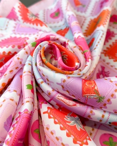 Macro shot of silk scarf with artistic fruit stamp prints and glossy vibrant texture