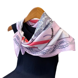 Foulard en soie rose avec motifs de chaînes bleues sur un haut noir et cintre