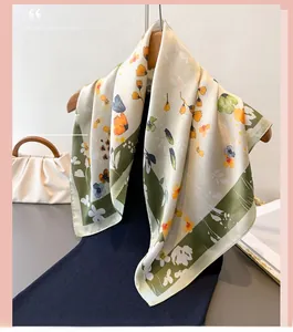 Detail of floral printed faux silk scarf draped elegantly on a wooden hanger with a handbag