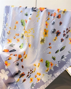 Close-up of floral print silk scarf with refined rolled edges and smooth texture