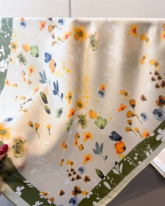 Close-up of floral print silk scarf showing smooth texture and elegant green border detail