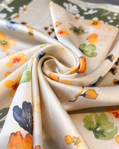 Detailed view of the champagne silk scarf with floral print and olive green border