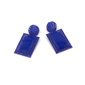 Detailed view of geometric blue drop earrings with pavé crystals and sapphire blue resin
