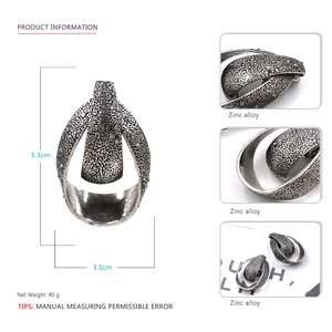 Detailed view of vintage metal teardrop earrings with hammered texture and zinc alloy specs