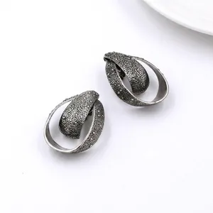Vintage metal teardrop earrings with textured silver finish and sparkling crystal accents