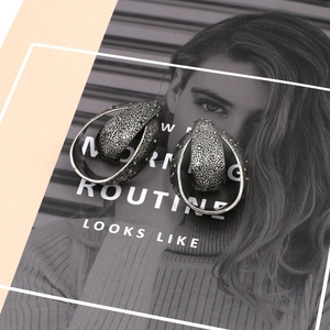 Vintage silver hollow teardrop earrings with textured hammered finish and white zircons