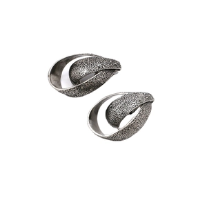 Vintage teardrop metal earrings with pitted texture and small crystals on white background