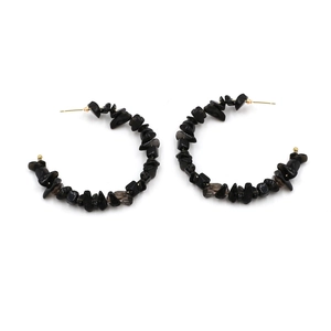 Macro detail of Bohemian C-shape hoop earrings featuring black natural stone beads
