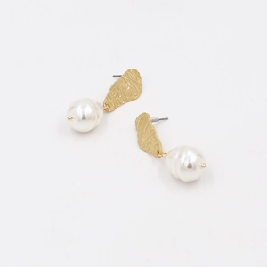 Elegant gold textured metal earrings with large white pearls on a minimalist white background