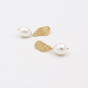 Baroque pearl drop earrings with golden hammered metal clasp shown from a 45-degree angle