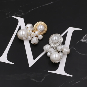 Détail de boucles d'oreilles en perles avec disques métalliques martelés sur marbre