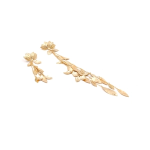 Long gold metal leaf tassel earrings with textured layers on white background