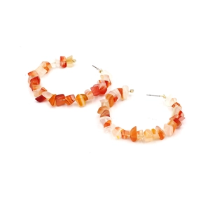 Detail of bohemian C-shaped earrings with colorful crushed stones and handmade beads