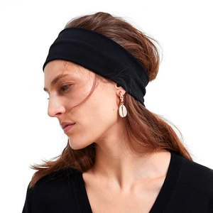 Fascia sportiva nera ampia ed elastica minimalista indossata da una modella su sfondo bianco