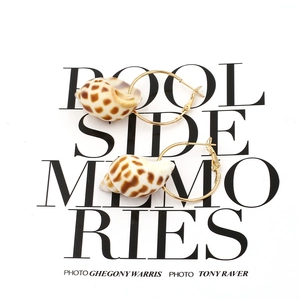 Golden hoop earrings with spotted shell pendants shown on pool-side background card